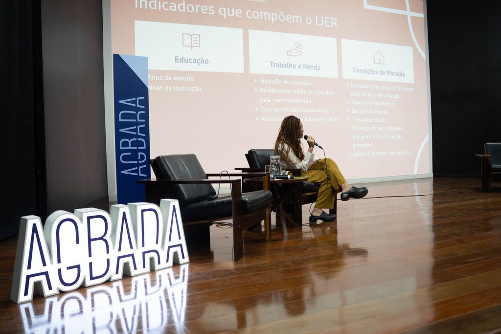 Priscila Soares apresentando as 3 dimensões do IJER: Educação, Trabalho e Renda e Condições de Moradia durante o Fórum Econômico de Mulheres Negras Brasil, 2026